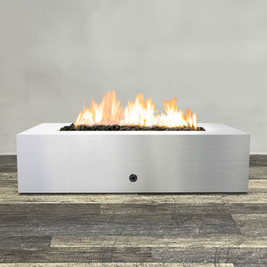 Front view of 60" x 32" Rectangle Gravity Stainless Steel Fire Pit by Starfire Designs - Brown with flames on, featuring sleek modern design and durable construction, perfect for outdoor patio spaces. Natural gas or propane compatible, enhancing warmth and ambiance. Lava rocks included for added aesthetic.