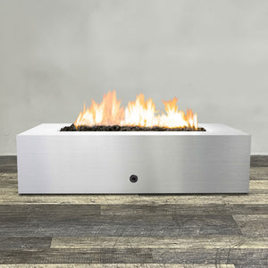 Front view of 60" x 32" Rectangle Gravity Stainless Steel Fire Pit by Starfire Designs - Brown with flames on, featuring sleek modern design and durable construction, perfect for outdoor patio spaces. Natural gas or propane compatible, enhancing warmth and ambiance. Lava rocks included for added aesthetic.