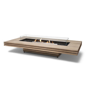 The EcoSmart Fire Gin 90 Low Teak gas fire table showcases a stunning teak wood base paired with a stainless steel burner and wind guard, offering an elegant and durable centerpiece for outdoor patios and entertainment spaces. This rectangular gas fire pit is engineered for both natural gas and propane use, delivering a stylish and functional fire feature for modern outdoor designs.