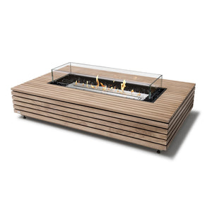 EcoSmart Fire Wharf 50 Teak fire pit table with a stainless steel burner and protective glass wind guard, creating a contemporary focal point for outdoor living areas. The sleek teak wood frame adds natural elegance, making it a stylish choice for luxury patios, outdoor lounges, and modern fire pit setups. This natural gas or propane fire pit produces a clean-burning flame for sophisticated entertaining spaces.