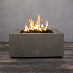 Starfire Designs Gravity 36-inch square concrete gas fire pit in brown with bright flames rising from black lava rocks. Modern outdoor fire pit made from durable concrete for residential and commercial use. Perfect for patios and backyards, this luxury fire pit adds warmth and ambiance. High-quality fire pit with stainless steel burner and propane/natural gas compatibility