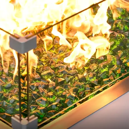A closeup of 1 inch fire glass in diamond shapes in a fire pit closeup photo in emerald green