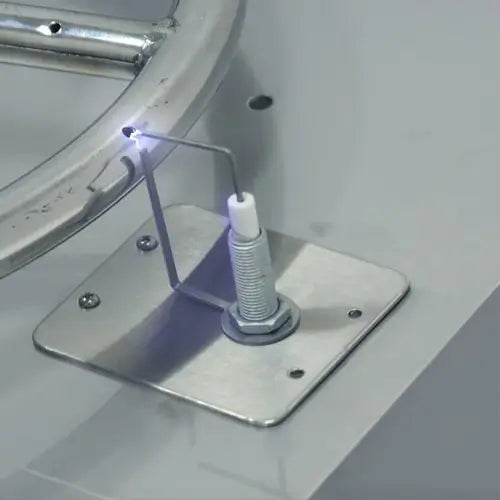 A closeup of the push button spark ignition system sparking the gas of a DIY fire pit