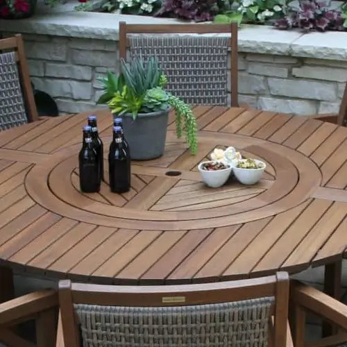 a lazy susan turning table top is flush with the patio table it's on covered with beer bottles and small bowls and a plant to receive guests