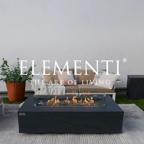 Elementi rectangular outdoor fire table with a sleek black concrete finish, tempered glass wind guard, and lively flames over crushed fire glass, ideal for modern patio setups and luxurious outdoor gatherings.