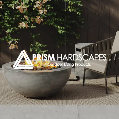 Prism Hardscapes round concrete fire pit bowl set on a stylish patio with lush greenery. This modern outdoor fire pit adds warmth, elegance, and functionality to backyard and patio living spaces