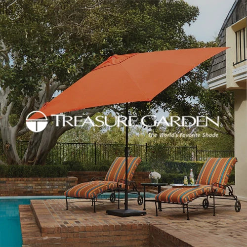 Treasure Garden outdoor patio umbrella in vibrant orange providing shade over two stylish striped lounge chairs by a brick poolside patio, surrounded by lush greenery and a serene outdoor setting.