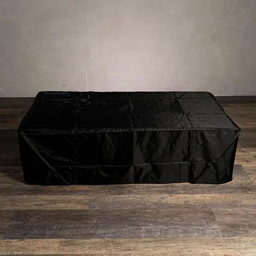 a large, rectangular, black vinyl fire pit cover is on display in a photostudio