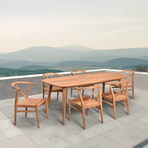A luxurious teak dining set with a large wooden rectangular table and eight elegant wishbone-style chairs, perfectly placed on a scenic mountaintop terrace.