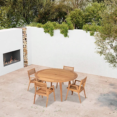 A teak wood round dining set featuring a spacious circular table and four slatted-back chairs, elegantly positioned in a minimalist outdoor space with a fireplace. 