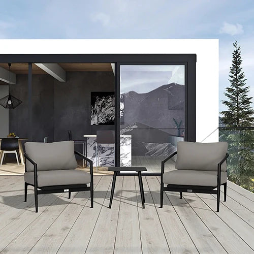 A sophisticated outdoor lounge set featuring two black-framed club chairs with plush gray cushions and a minimalist black metal side table, placed on a stylish wood deck with a scenic mountain view.