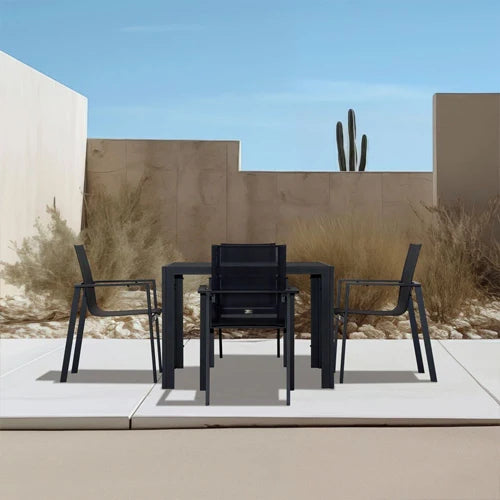  A sleek black outdoor dining set from the Harmonia Living Collection, featuring a minimalist rectangular table with four matching stackable chairs.