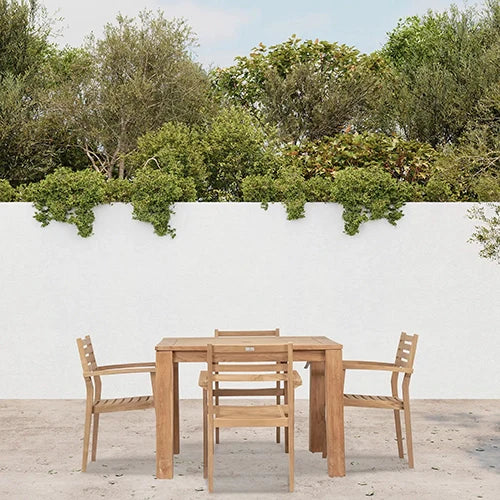 The Harmonia Living Sylvan Teak Dining Set features a solid teak dining table paired with slatted teak armchairs, creating a timeless and elegant outdoor dining experience.
