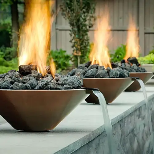 three copper fire and water bowls pour into a modernpool 