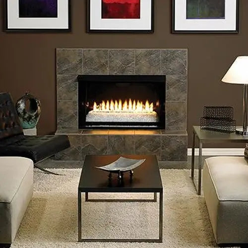 a ventless modern fireplace is ignited and on display in a modern living room with suede couches and a mini table 