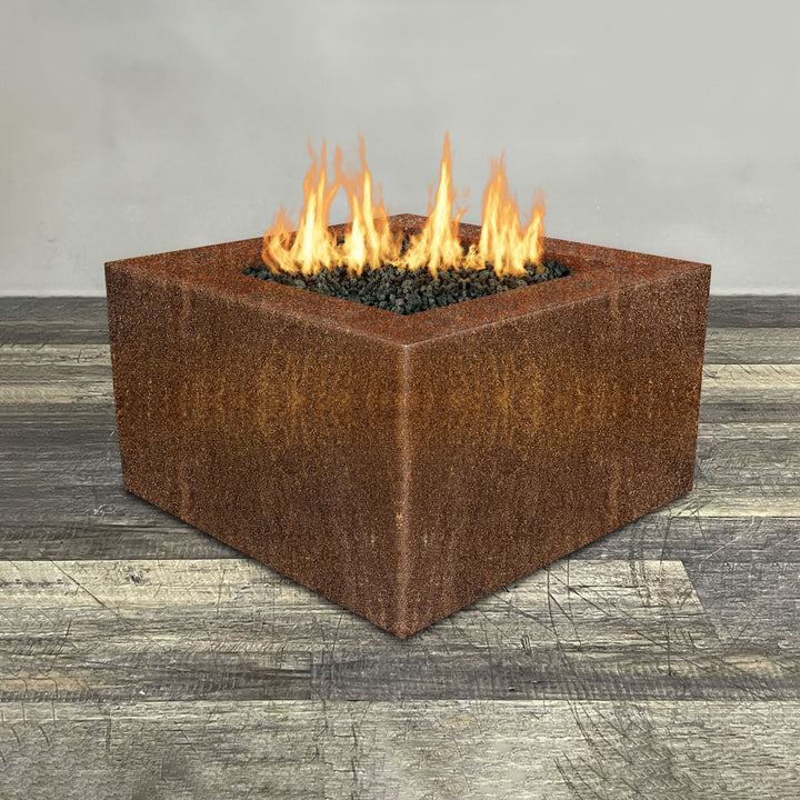 Front view of 36" Square Gravity Corten Steel Fire Pit - Propane Gas Hardline - 110V CSA Hi/Lo Electronic Ignition System w/Bluetooth & Handheld Remote by Starfire Designs - Brown with flames on, featuring sleek modern concrete design and durable construction, perfect for outdoor patio spaces. Natural gas or propane compatible, enhancing warmth and ambiance. Lava rocks included for added aesthetic.