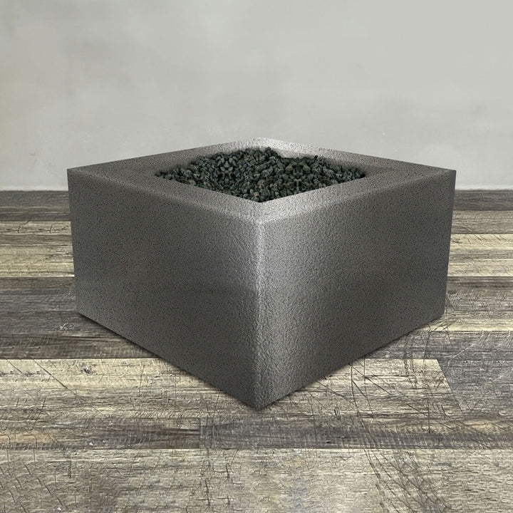 A side view of the 36" Square Gravity Powder Coated Steel Fire Pit - Propane Gas Hardline - Flame Sense with Spark Ignition System - Silver Hammertone by Starfire Designs - perfect for outdoor patio spaces. Natural gas or propane compatible, enhancing warmth and ambiance. Lava rocks included for added aesthetic.