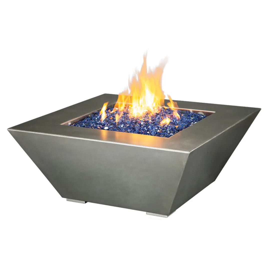 Contemporary square fire pit with a sleek, angular design, featuring a stainless-steel finish and filled with vibrant blue fire glass, emitting a warm and inviting flame