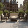 A brown fire bowl sits on a city balcony patio, flanked by two armchairs and a small sofa. The setting is framed by planters and a classic brick building background in daylight. The steady flame of the patio fire pit creates an inviting spot for outdoor entertaining, demonstrating the suitability of a smokeless fire pit for creating a cozy backyard fire pit atmosphere in urban spaces.