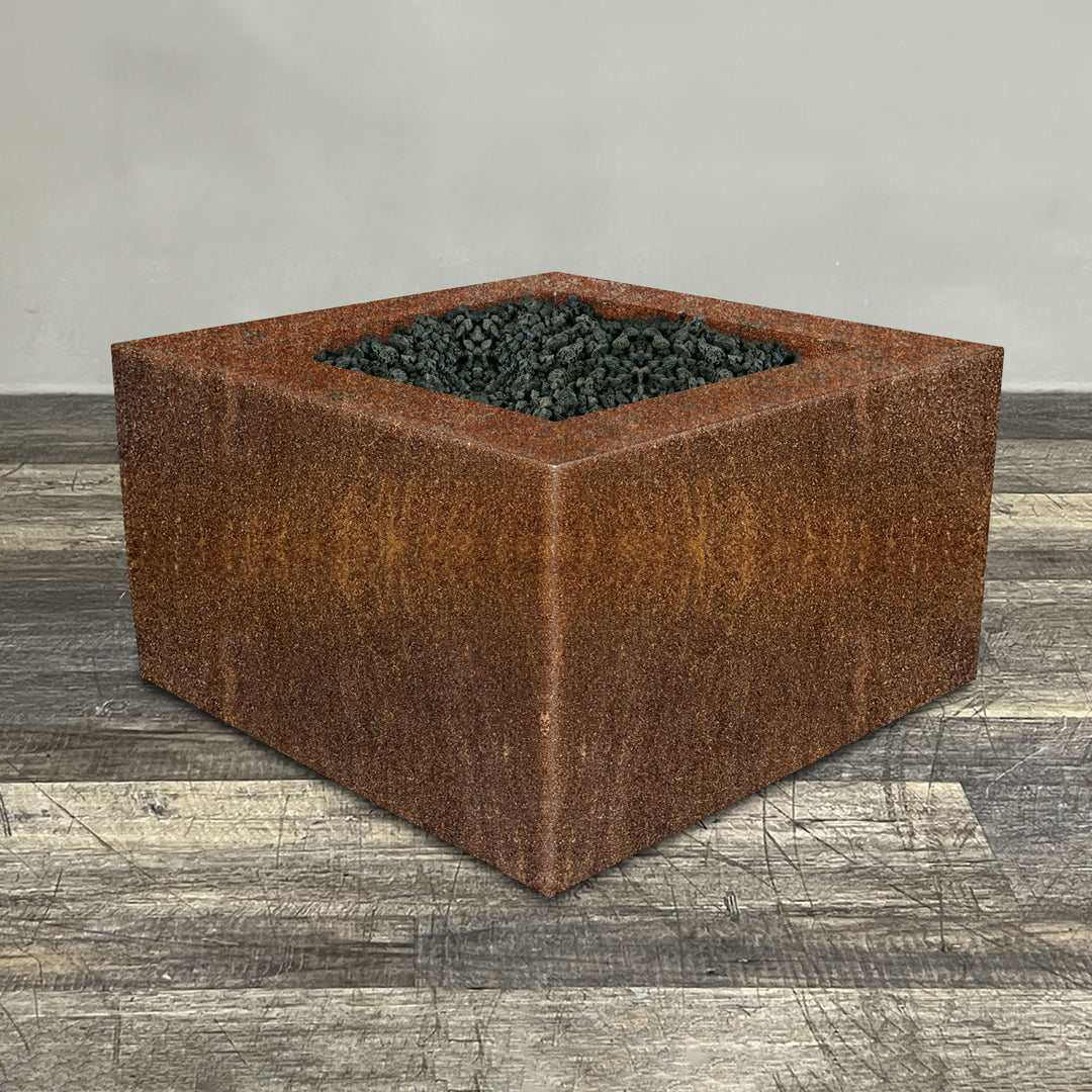 A side view of the 45" Square Gravity Corten Steel Fire Pit by Starfire Designs - perfect for outdoor patio spaces. Natural gas or propane compatible, enhancing warmth and ambiance. Lava rocks included for added aesthetic.