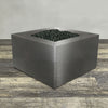 A side view of the 45" Square Gravity Powder Coated Steel Fire Pit - Natural Gas - 110V Electronic Ignition System - Silver Hammertone by Starfire Designs - perfect for outdoor patio spaces. Natural gas or propane compatible, enhancing warmth and ambiance. Lava rocks included for added aesthetic.
