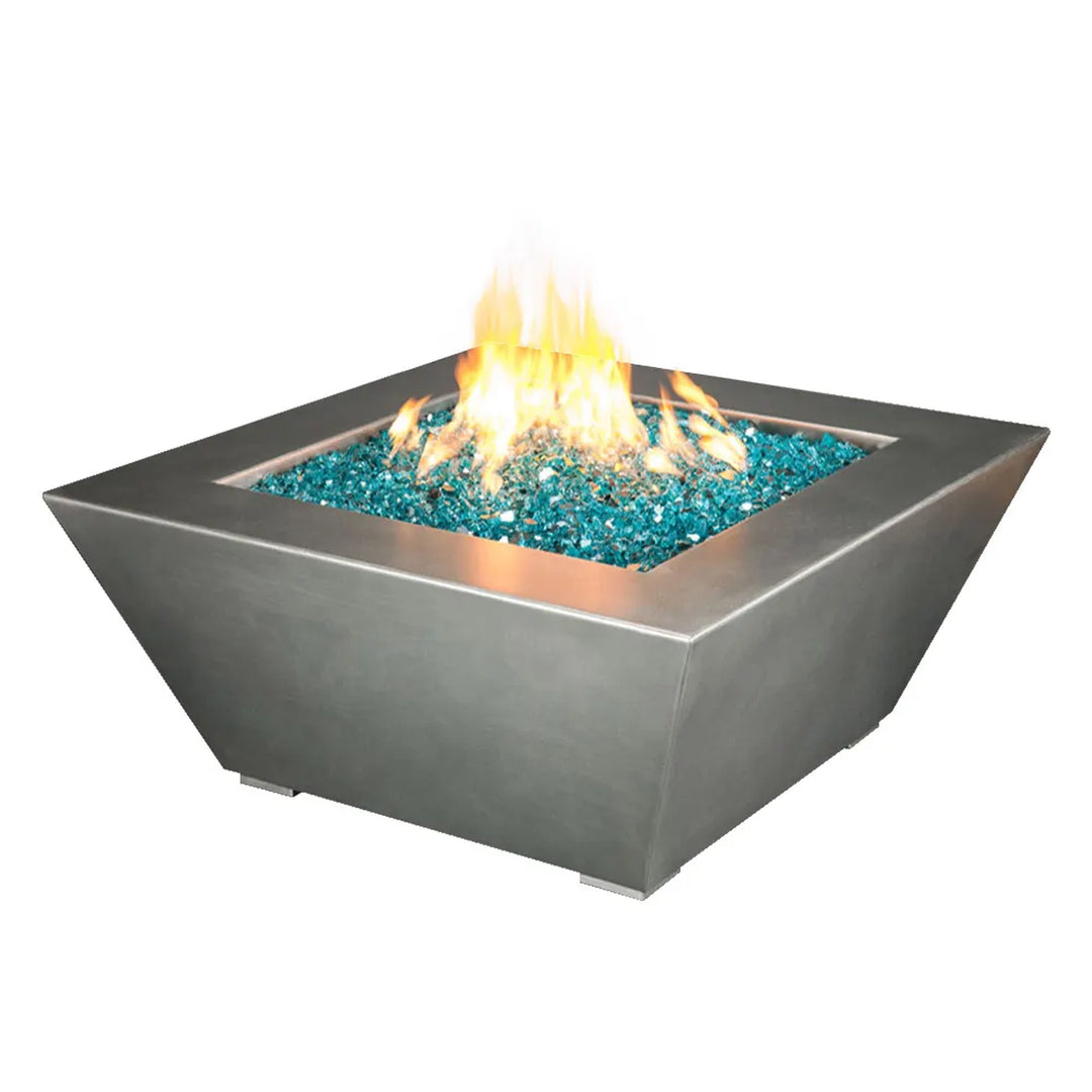 Large square fire pit with a modern stainless steel finish, featuring a 48-inch body and 24-inch height, filled with turquoise fire glass and producing a bright, warm flame