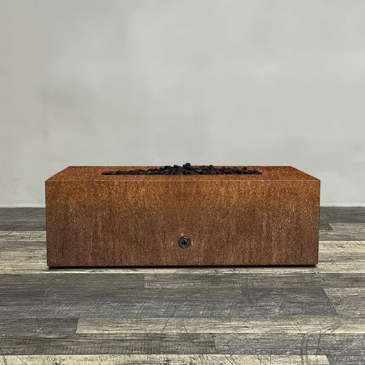 A side view of the 48" x 24" Rectangle Gravity Corten Steel Fire Pit by Starfire Designs - perfect for outdoor patio spaces. Natural gas or propane compatible, enhancing warmth and ambiance. Lava rocks included for added aesthetic.