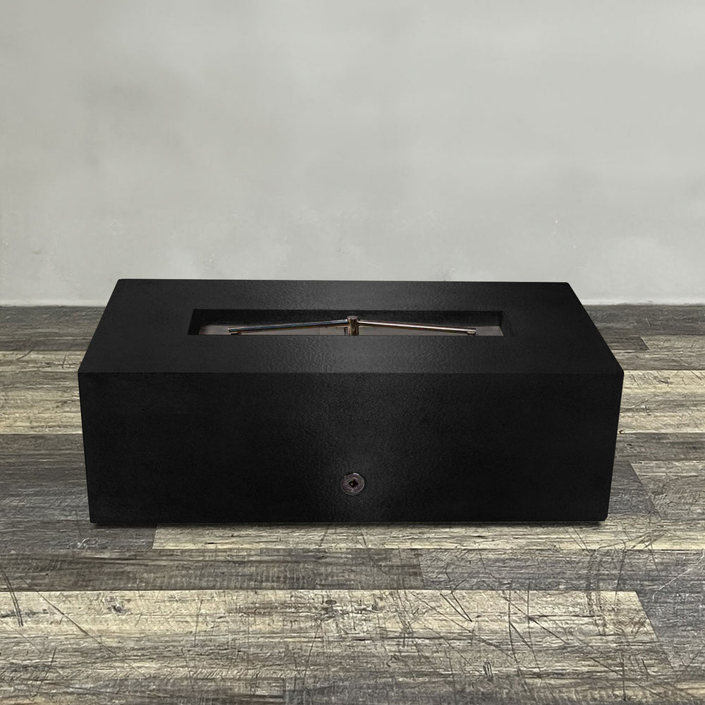 A side view of the 48" x 24" Rectangle Gravity Powder Coated Steel Fire Pit - Natural Gas - 110V Electronic Ignition System - Black Hammertone by Starfire Designs - perfect for outdoor patio spaces. Natural gas or propane compatible, enhancing warmth and ambiance. Lava rocks included for added aesthetic.