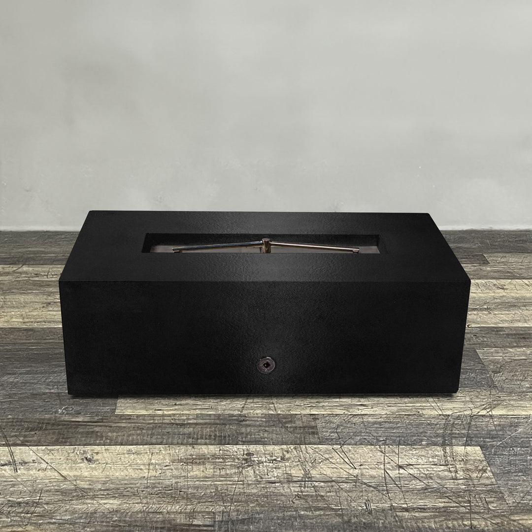 A side view of the 48" x 24" Rectangle Gravity Powder Coated Steel Fire Pit - Natural Gas - 110V Electronic Ignition System - Black Hammertone by Starfire Designs - perfect for outdoor patio spaces. Natural gas or propane compatible, enhancing warmth and ambiance. Lava rocks included for added aesthetic.