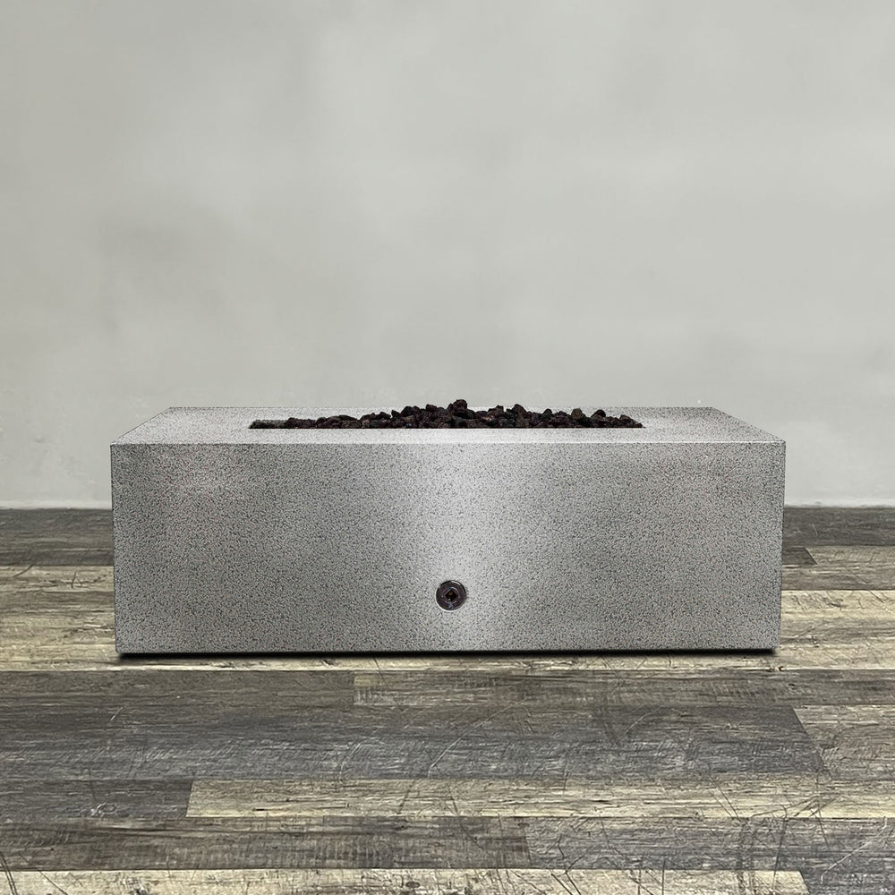 A side view of the 48" x 24" Rectangle Gravity Powder Coated Steel Fire Pit - Propane Gas Hardline - Push Button Spark Ignition - Silver Hammertone by Starfire Designs - perfect for outdoor patio spaces. Natural gas or propane compatible, enhancing warmth and ambiance. Lava rocks included for added aesthetic.