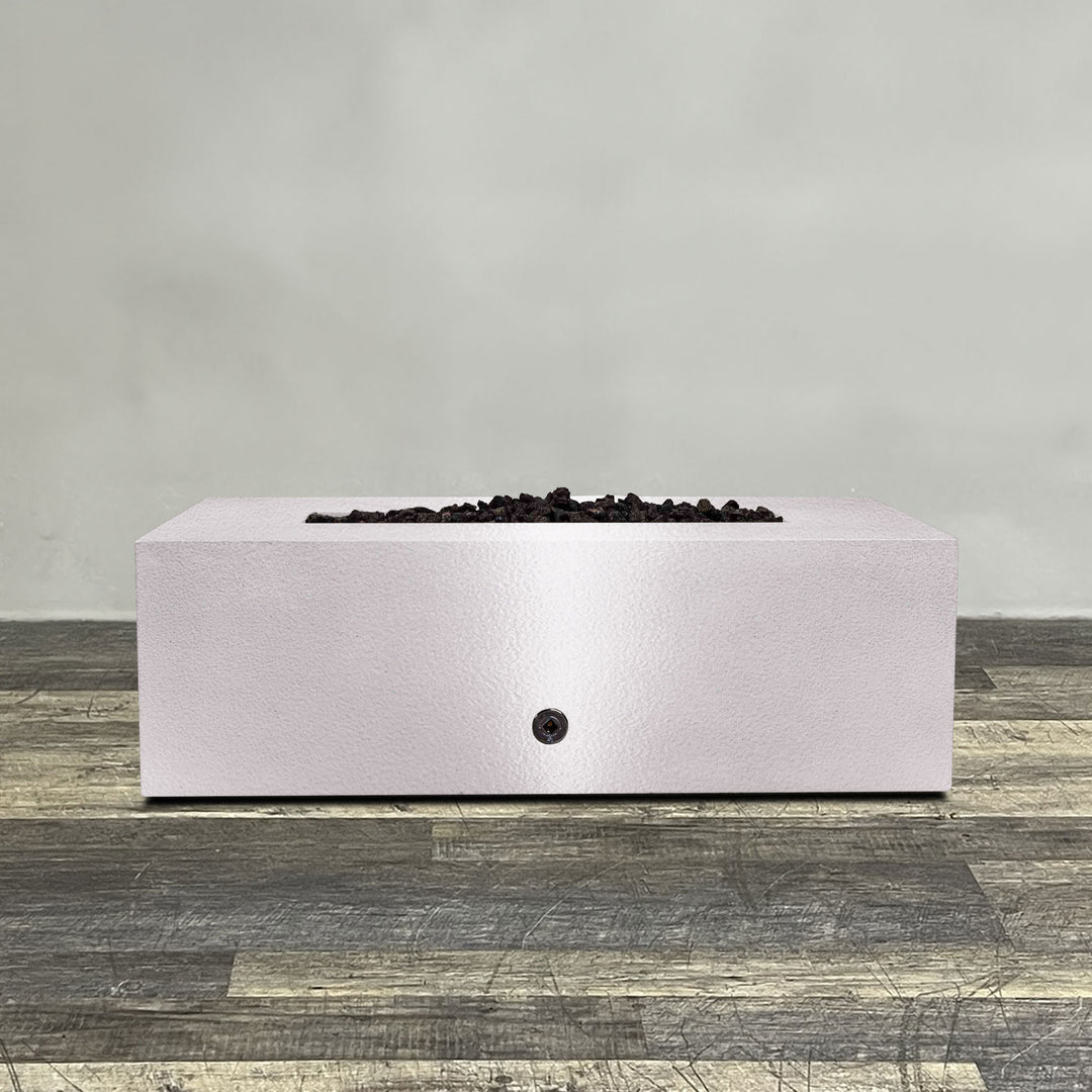 A side view of the 48" x 24" Rectangle Gravity Powder Coated Steel Fire Pit - Propane Gas Hardline - 110V CSA Hi/Lo Electronic Ignition System w/Bluetooth & Handheld Remote - White Hammertone by Starfire Designs - perfect for outdoor patio spaces. Natural gas or propane compatible, enhancing warmth and ambiance. Lava rocks included for added aesthetic.