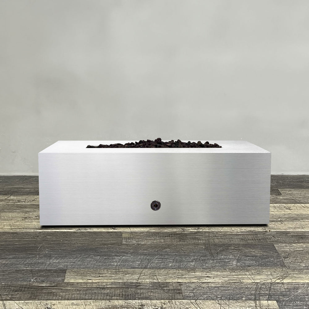 A side view of the 48" x 24" Rectangle Gravity Stainless Steel Fire Pit by Starfire Designs - perfect for outdoor patio spaces. Natural gas or propane compatible, enhancing warmth and ambiance. Lava rocks included for added aesthetic.
