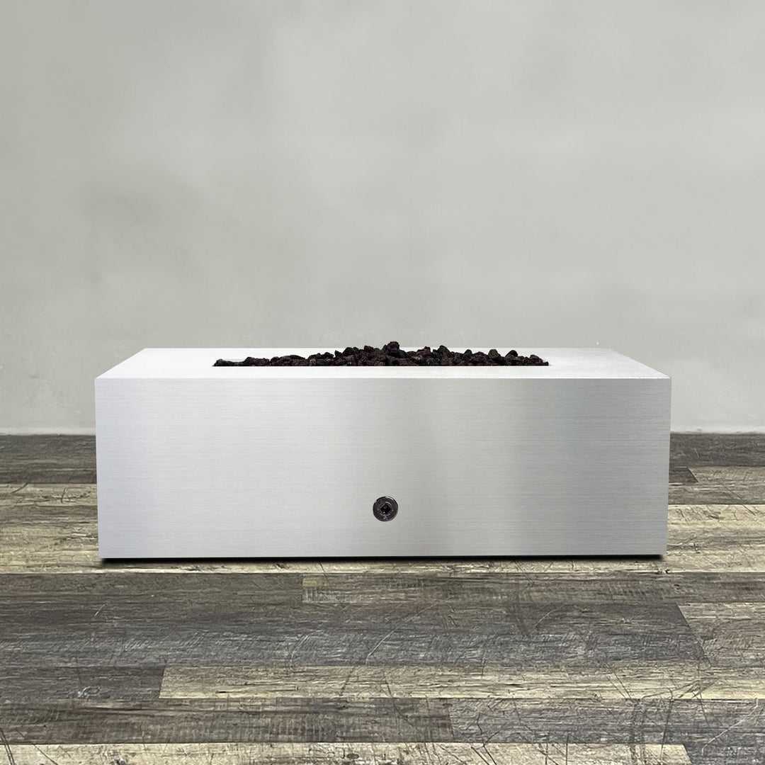 A side view of the 48" x 24" Rectangle Gravity Stainless Steel Fire Pit by Starfire Designs - perfect for outdoor patio spaces. Natural gas or propane compatible, enhancing warmth and ambiance. Lava rocks included for added aesthetic.
