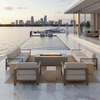 A sleek waterfront terrace features a gray modern fire pit sitting on a rug between two white sofas. The scene overlooks an infinity pool and city skyline at sunset, highlighting the clean lines of the fire feature. The bright, clean flames demonstrate the benefits of a smokeless fire pit, with the gas fire pit adding warmth to the contemporary outdoor lounge.
