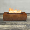 A side view of the 60" x 24" Rectangle Gravity Corten Steel Fire Pit by Starfire Designs - perfect for outdoor patio spaces. Natural gas or propane compatible, enhancing warmth and ambiance. Lava rocks included for added aesthetic.