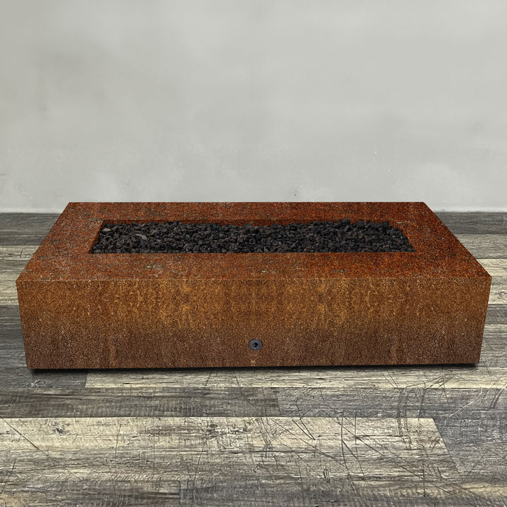 A side view of the 72" x 38" Rectangle Gravity Corten Steel Fire Pit by Starfire Designs - perfect for outdoor patio spaces. Natural gas or propane compatible, enhancing warmth and ambiance. Lava rocks included for added aesthetic.