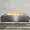 Front view of 72" x 38" Rectangle Gravity Powder Coated Steel Fire Pit - Natural Gas - 110V CSA On/Off Electronic Ignition System - Silver Hammertone by Starfire Designs - Brown with flames on, featuring sleek modern concrete design and durable construction, perfect for outdoor patio spaces. Natural gas or propane compatible, enhancing warmth and ambiance. Lava rocks included for added aesthetic.