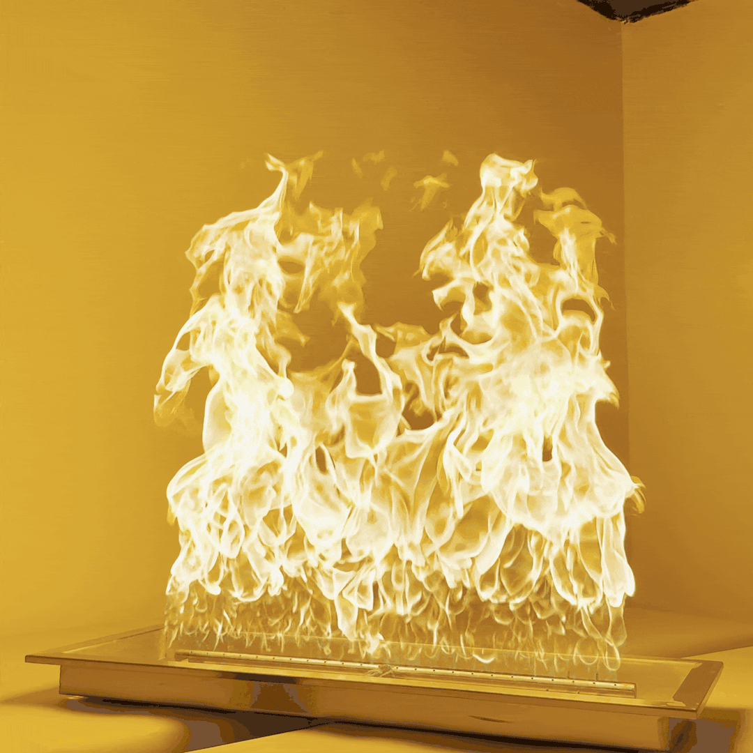 Captivating animation of the Athena Fire Glass 30" x 10" Rectangle Drop-In Pan with powerful H-Burner, producing vibrant, towering golden flames. This 500,000 BTU-rated burner delivers intense heat and stunning visual impact, making it ideal for large custom fire pits and high-performance gas fire features. Showcased in a modern, enclosed setting, this GIF highlights the dramatic flame presentation and sleek stainless steel pan design / perfect for luxury outdoor spaces and professional installations.