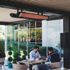 Contemporary commercial patio space with Bromic Tungsten Electric Smart-Heat heater installed overhead, creating a warm, inviting atmosphere for outdoor meetings and casual dining.