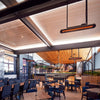 Stylish restaurant interior featuring ceiling-mounted Bromic Tungsten Electric Smart-Heat heaters, warming a vibrant dining area with wood and marble finishes.