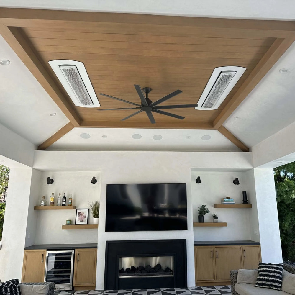 Contemporary outdoor living area featuring Bromic Tungsten Smart-Heat heaters installed with white recessed kits, warming a patio with a modern fireplace and large ceiling fan.