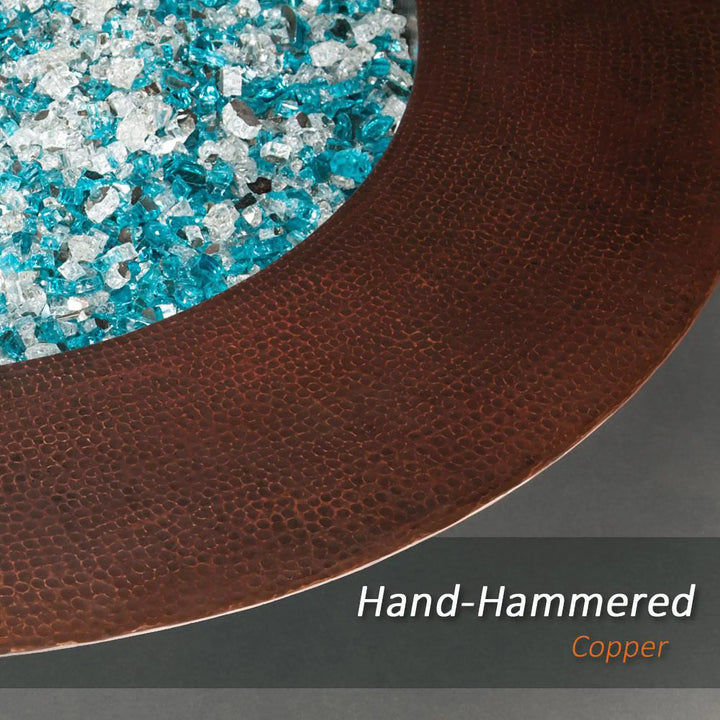 Close-up of the Cono Moreno 48-inch Round Copper Fire Pit featuring hand-hammered copper and blue fire glass, highlighting the intricate craftsmanship