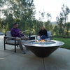 Cono Moreno 48-inch Round Copper Fire Pit in a luxurious backyard setting, featuring comfortable outdoor furniture and stunning scenery