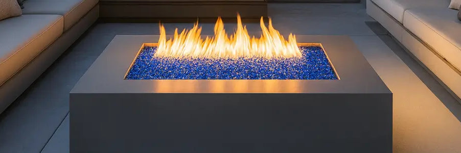 Modern outdoor fire pit table with flames and a gray sofa in the background