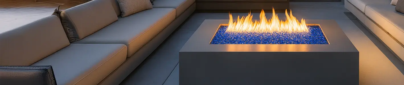 Modern outdoor fire pit table with flames and a gray sofa in the background
