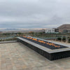 Expansive outdoor installation featuring a long linear fire feature overlooking desert landscapes, powered by the HPC Fire Inspired Linear Interlink Torpedo T-Burner for warm, dramatic flames.