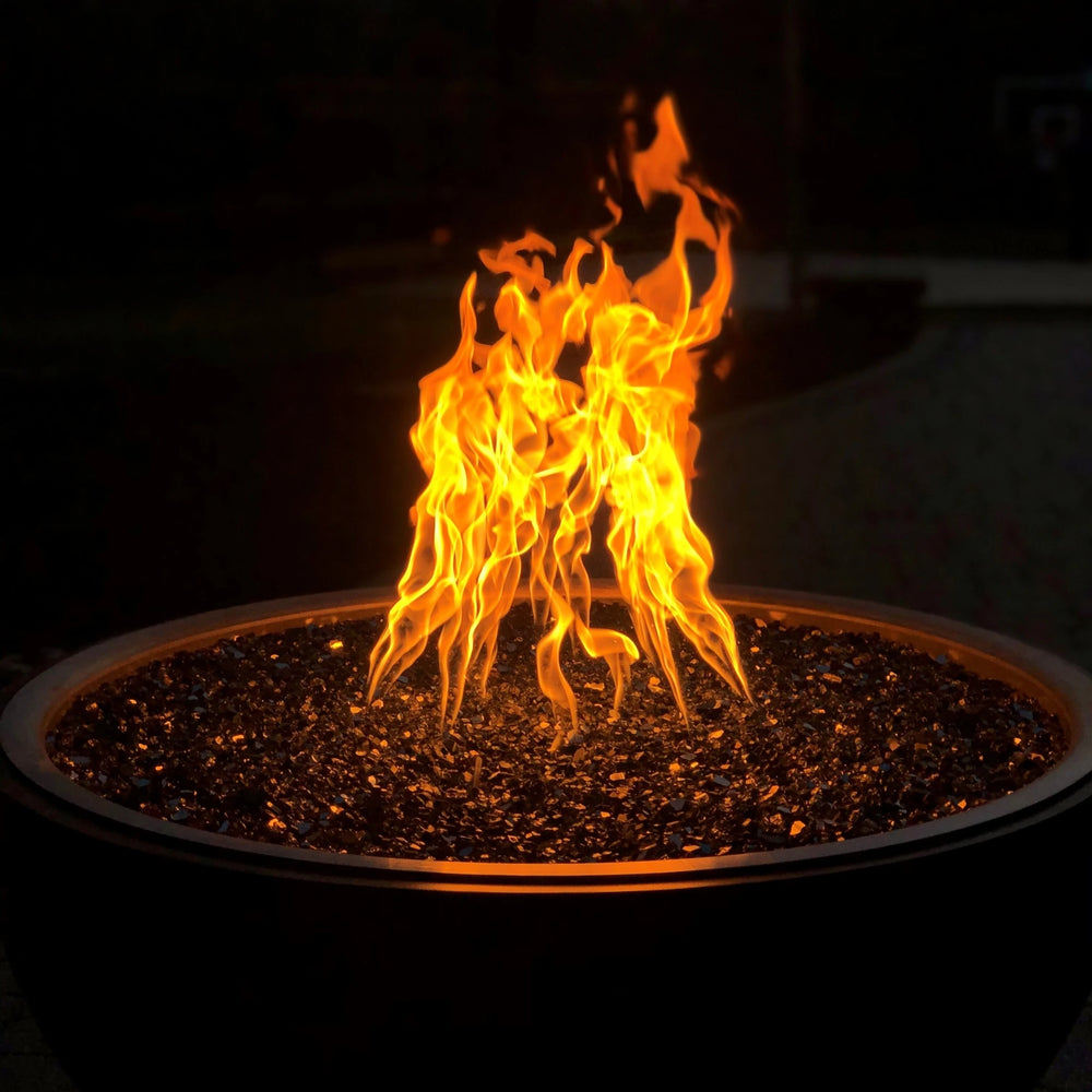 Vivid nighttime photo of fire pit using HPC’s Torpedo Penta Burner with fire glass media, displaying its signature tall, twisting flame pattern and warm ambiance.