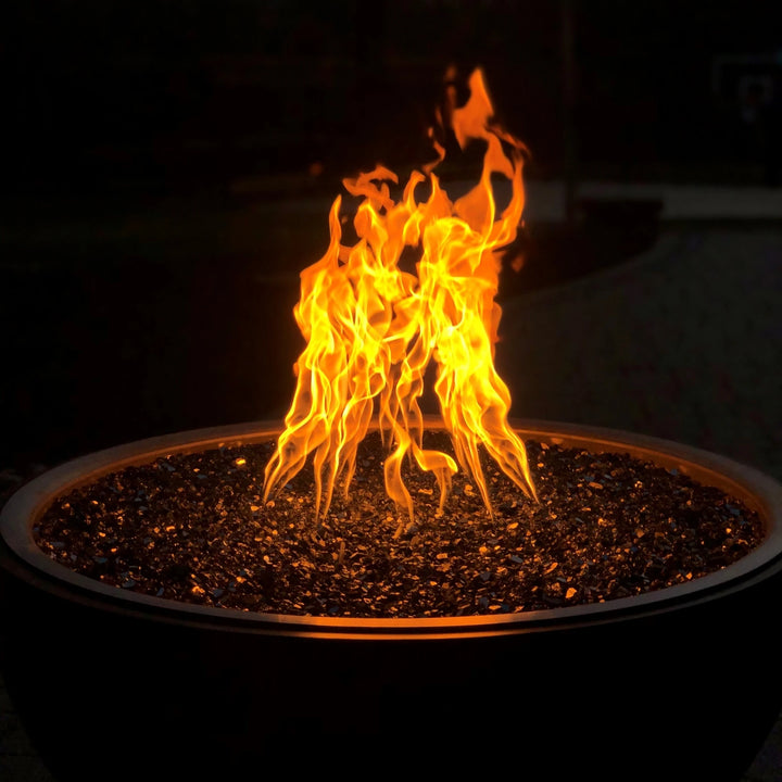 Vivid nighttime photo of fire pit using HPC’s Torpedo Penta Burner with fire glass media, displaying its signature tall, twisting flame pattern and warm ambiance.