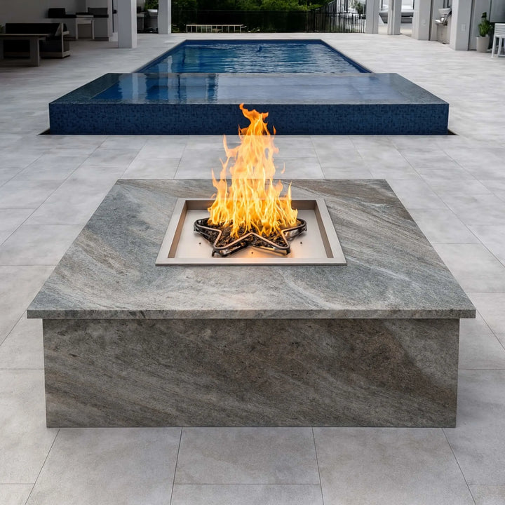 Poolside fire pit with a Square Drop-In Penta Burner installed in a luxurious granite-topped enclosure, producing elegant flames for elevated outdoor entertaining.