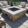 Rustic-chic patio space featuring a stone fire pit with HPC square flat burner technology, topped with black lava rock, surrounded by plush cream seating / blending natural textures with modern fire feature performance.